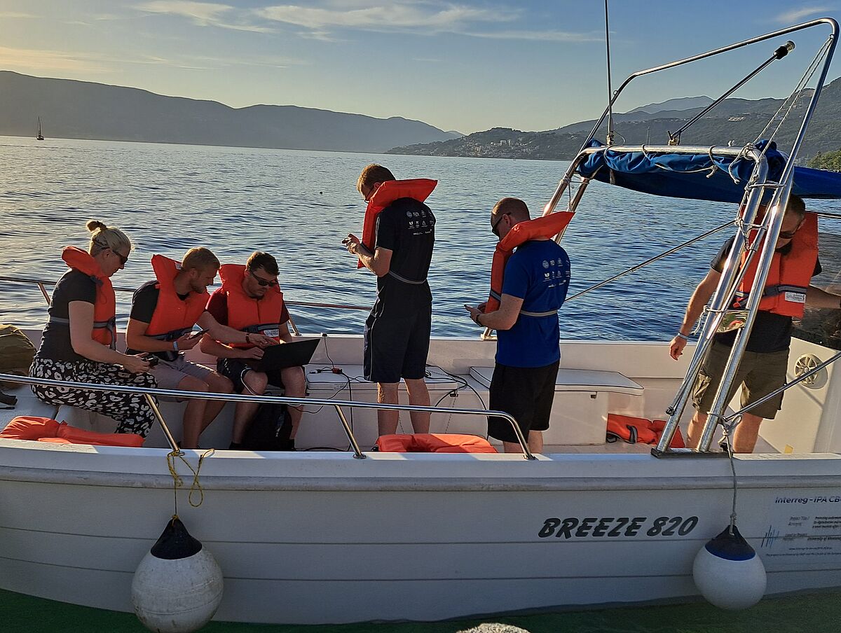 Die fünf Teams, die am diesjährigen Wettbewerb im Unterwasserlokalisieren in Montenegro teilnahmen, mussten die gesammelten Entfernungsdaten zunächst auf dem Schiff (Personen von links nach rechts: Dr. Sarah Jane Pell, Johannes Marx, Ian Karez, Sven Lack, Jeff Neasham) und anschließend offline analysieren, um die unbekannte Position eines in der Adria versenkten Transponders zu schätzen (Foto: Torsten Jeinsch/Universität Rostock).
