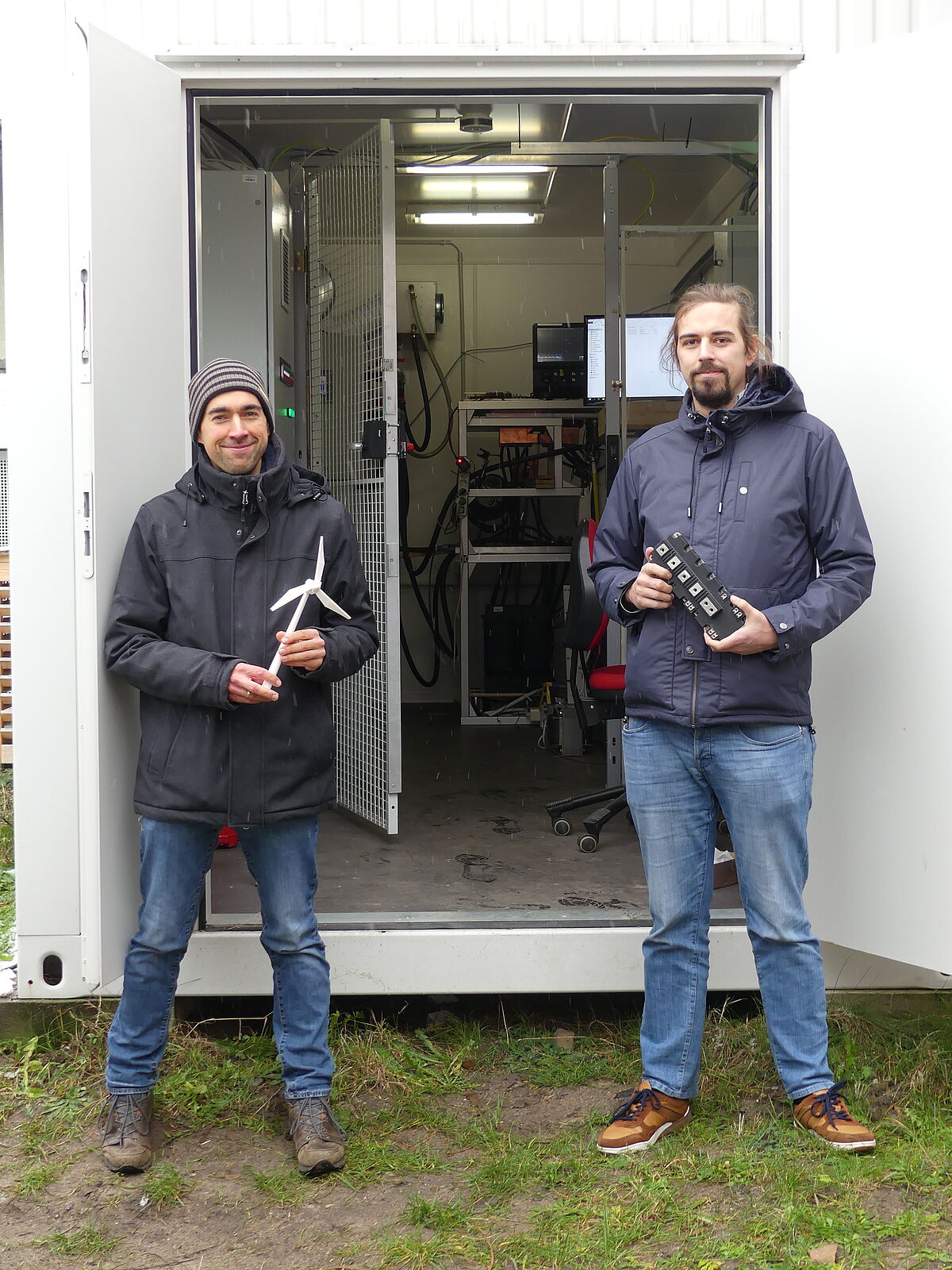 Arbeitsgruppenleiter Dr. Jan Fuhrmann (links) und Projektleiter M.Sc. Till-Mathis Plötz freuen sich über die erfolgreiche Inbetriebnahme des Prüfstandes für Windkraftanlagen-Umrichter. (Foto: Steffen Sänger).
